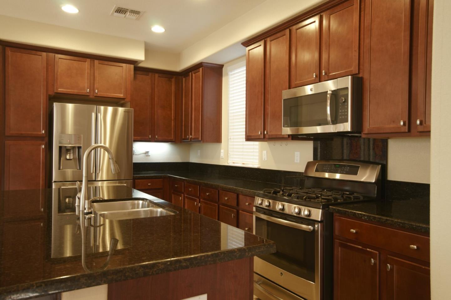 1579 Canal Street Milpitas, CA 95035 - Photo 9 of 36 a kitchen with granite countertop a refrigerator stove and microwave