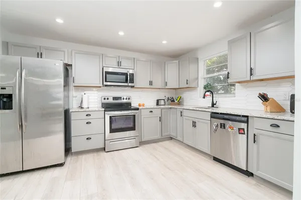 a kitchen with white cabinets and stainless steel appliances