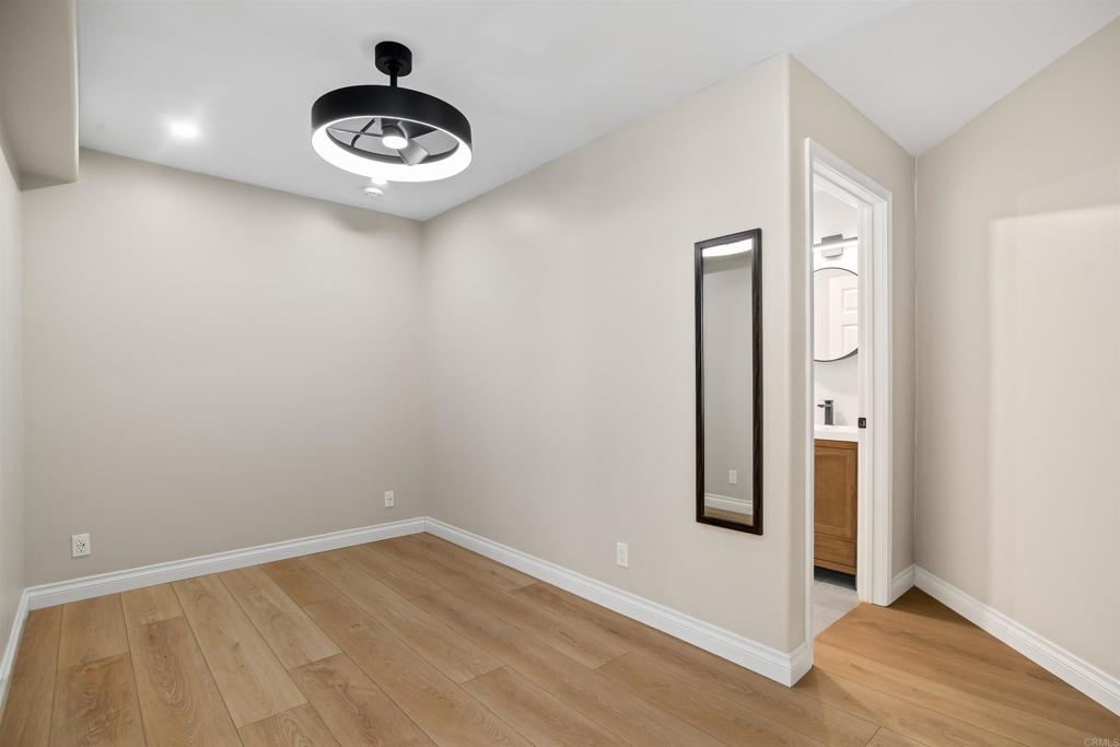 1622 Swallowtail Road Encinitas, CA 92024 - Photo 14 of 20 an empty room with wooden floor and windows
