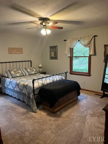 a bedroom with a bed a mirror and window