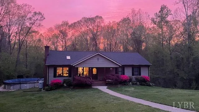 a front view of a house with a garden and trees