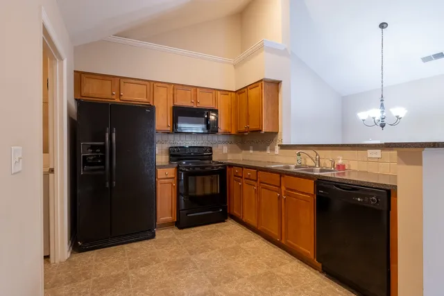 a kitchen with stainless steel appliances granite countertop a refrigerator and a sink