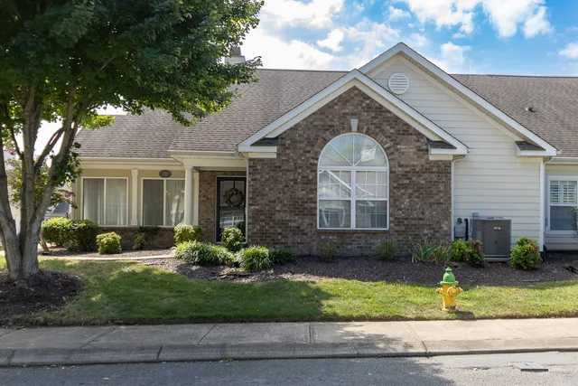 a front view of a house with a yard and potted plants