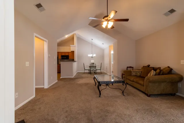 a living room with furniture and a chandelier