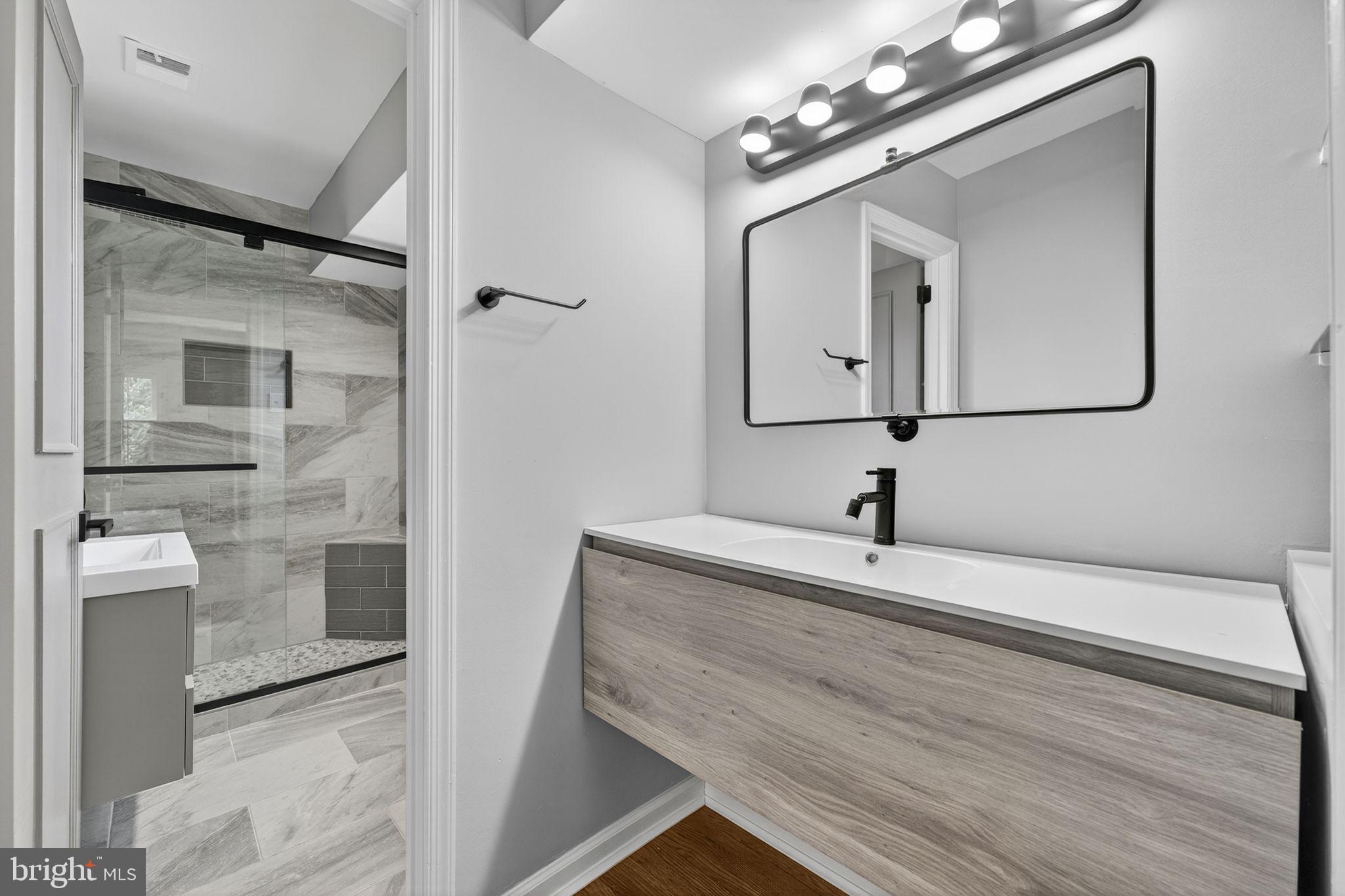 7009 Cold Spring Lane Alexandria, VA 22306 - Photo 17 of 30 a bathroom with a sink a large mirror and a shower