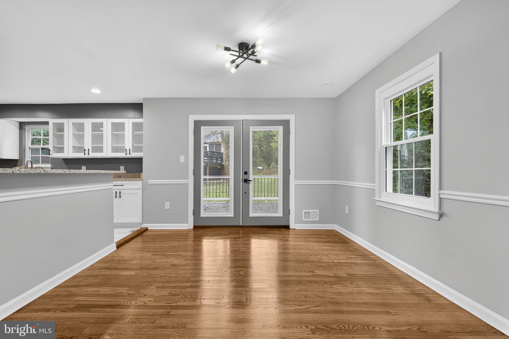 7009 Cold Spring Lane Alexandria, VA 22306 - Photo 5 of 30 a view of an empty room with a kitchen and wooden floor