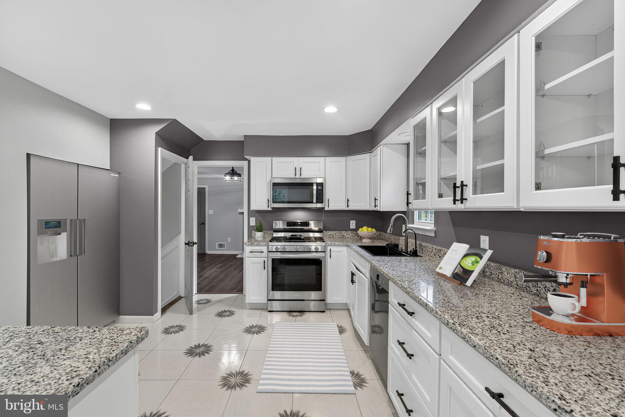 7009 Cold Spring Lane Alexandria, VA 22306 - Photo 6 of 30 a kitchen with stainless steel appliances granite countertop a sink refrigerator and cabinets