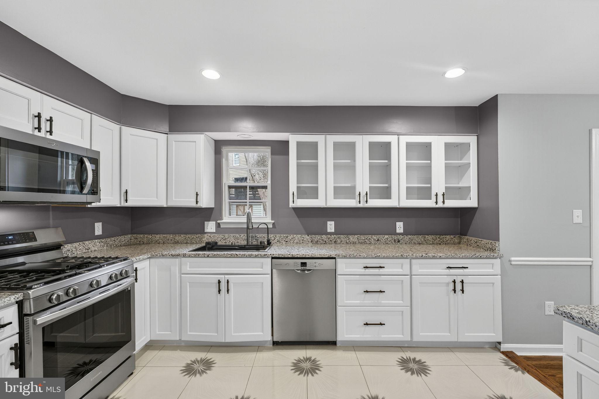 7009 Cold Spring Lane Alexandria, VA 22306 - Photo 8 of 30 a kitchen with granite countertop a sink a stove and cabinets