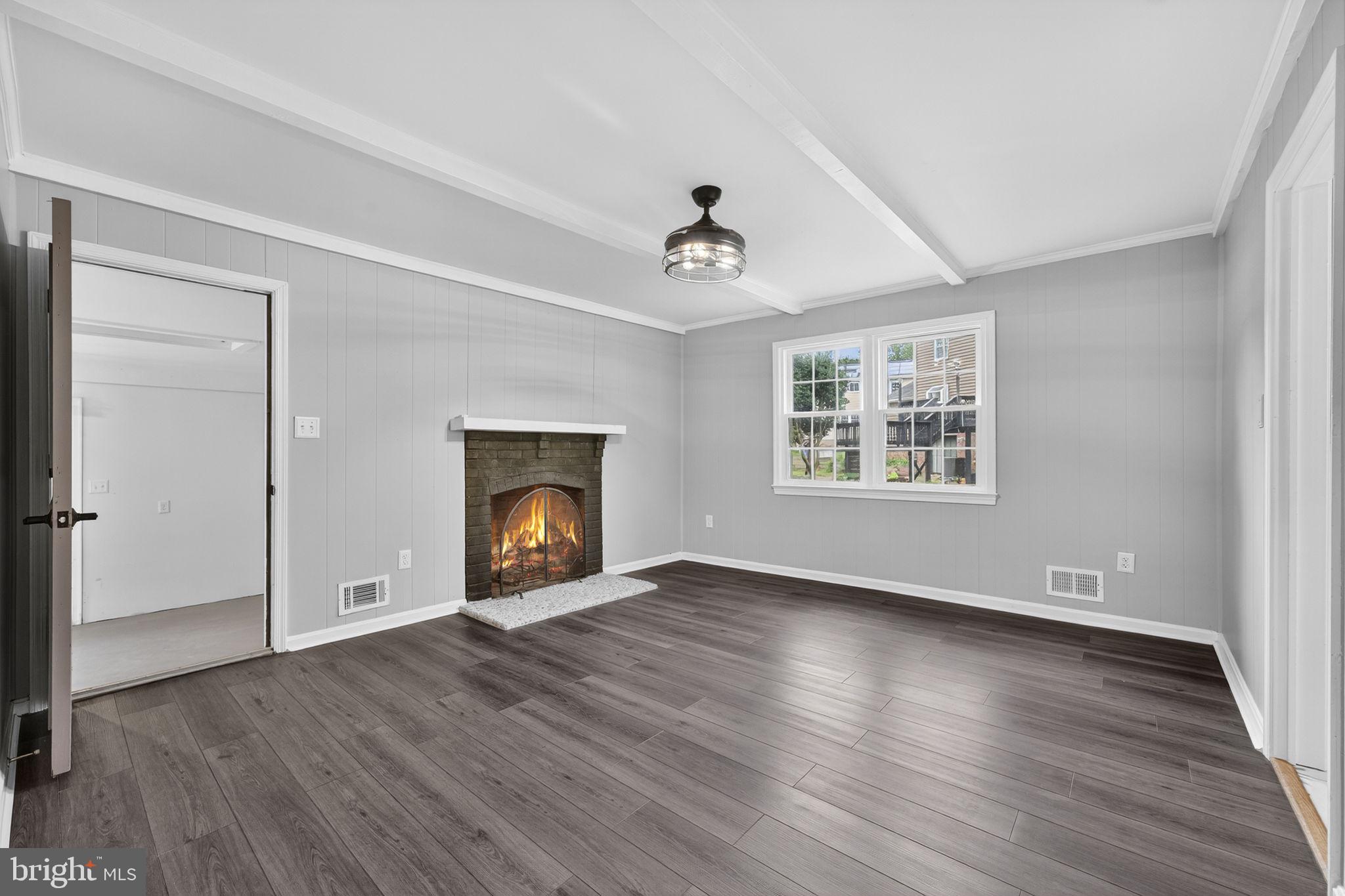 7009 Cold Spring Lane Alexandria, VA 22306 - Photo 10 of 30 an empty room with wooden floor a fireplace and windows