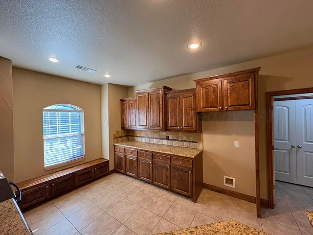 a view of kitchen with stainless steel appliances granite countertop a stove a sink and a refrigerator with wooden cabinets