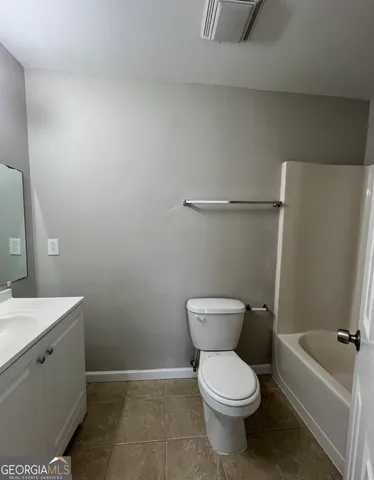 a white toilet sitting next to a bathroom sink