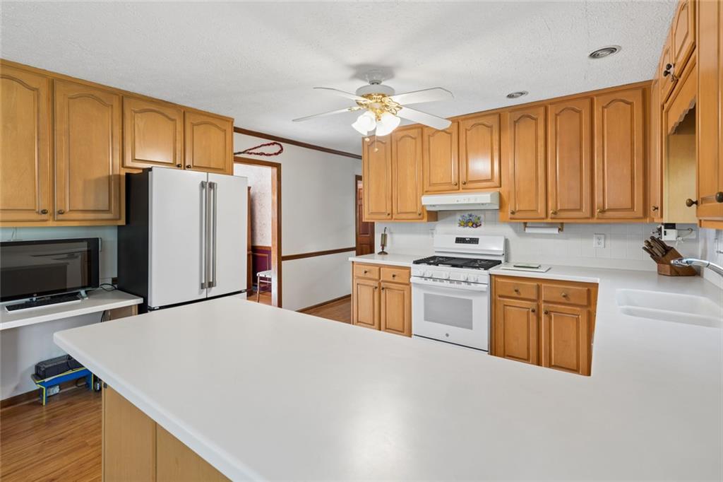 2931 Winding Circle Southwest Lilburn, GA 30047 - Photo 14 of 47 a kitchen with granite countertop a refrigerator a stove a sink dishwasher and wooden cabinets with wooden floor