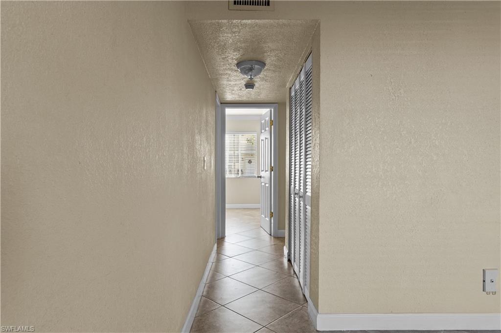 4615 Bayshore Drive, Unit E4 Naples, FL 34112 - Photo 16 of 30 a view of a hallway with wooden floor