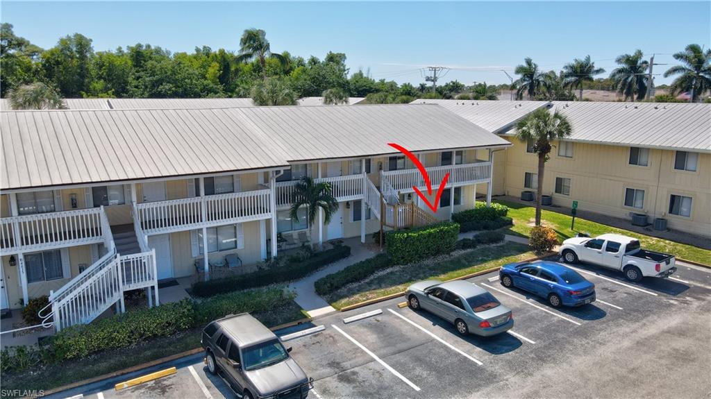 4615 Bayshore Drive, Unit E4 Naples, FL 34112 - Photo 22 of 30 an aerial view of a house roof deck with couches table and chairs with wooden fence