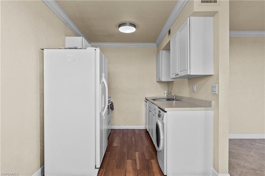 4615 Bayshore Drive, Unit E4 Naples, FL 34112 - Photo 4 of 30 a kitchen with a refrigerator a sink and wooden floor