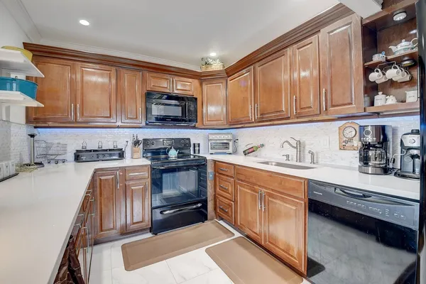 a kitchen with stainless steel appliances granite countertop a stove a sink and a microwave