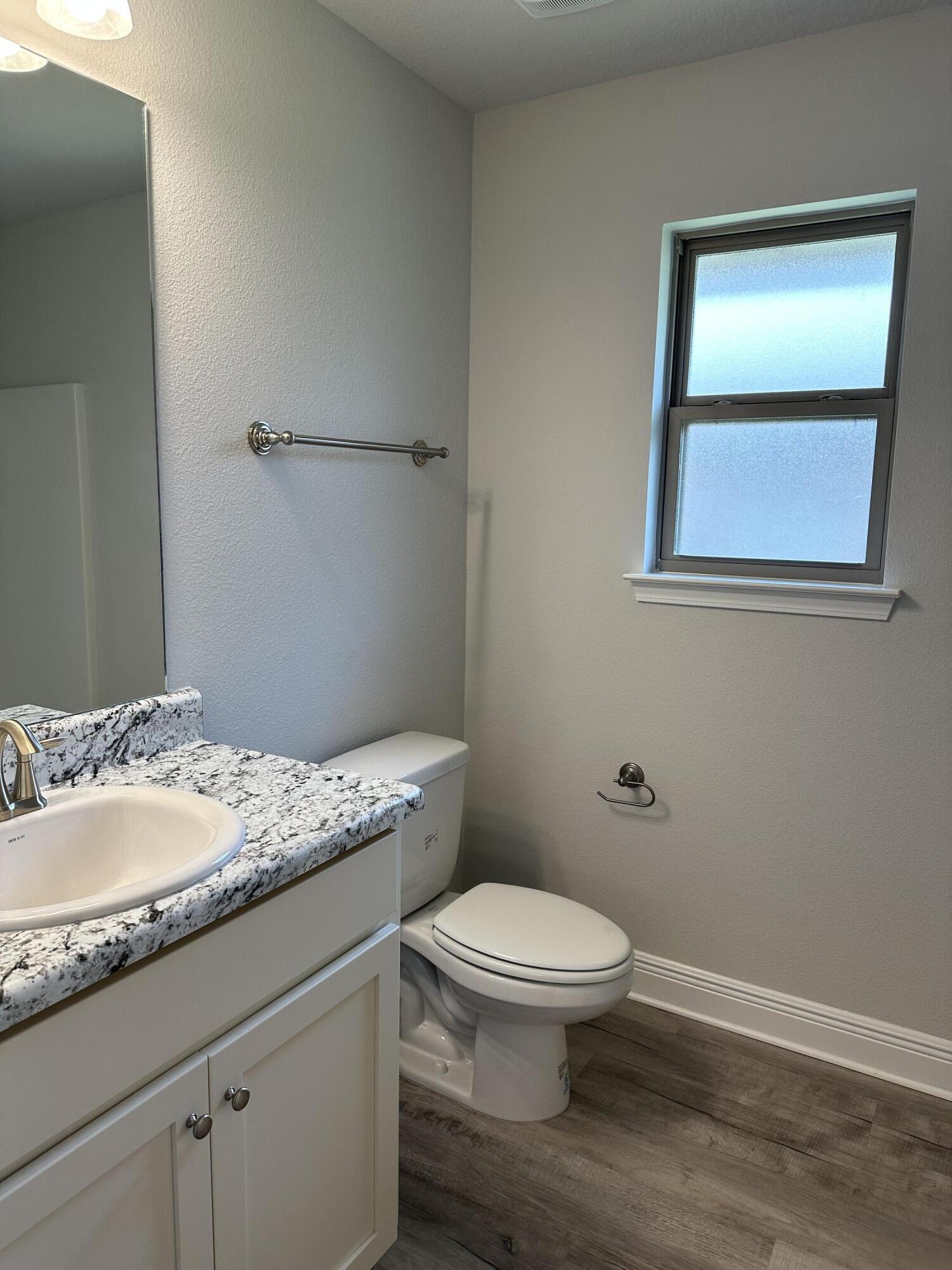 5287 Hidden Pines Circle Milton, FL 32583 - Photo 12 of 15 a bathroom with a granite countertop toilet a sink and a mirror