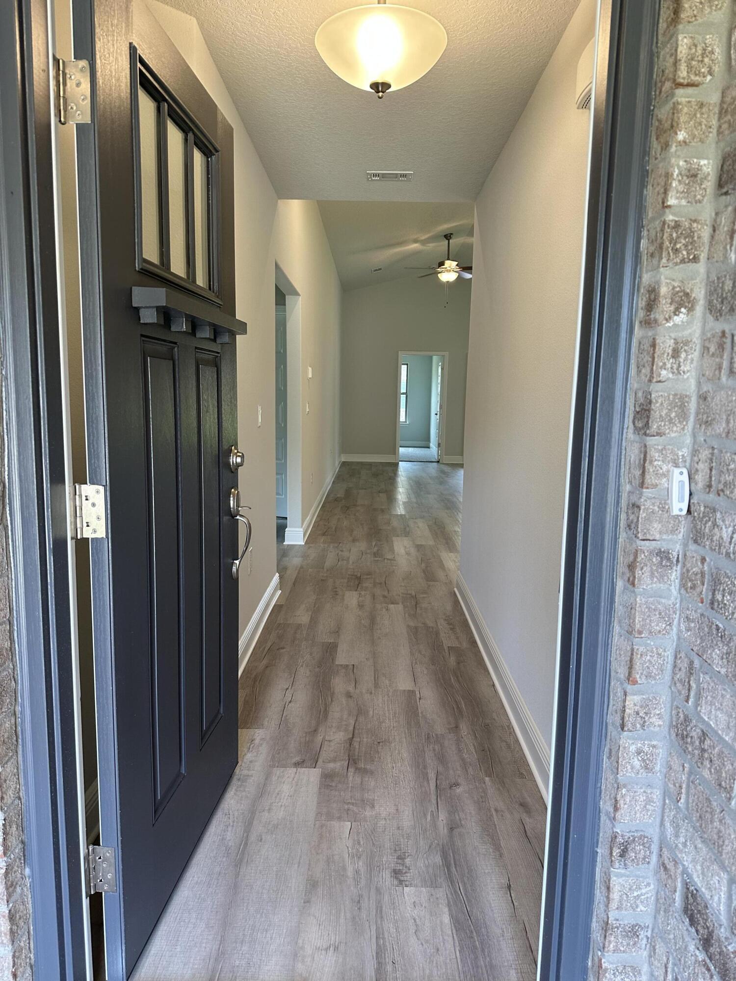 5287 Hidden Pines Circle Milton, FL 32583 - Photo 3 of 15 a view of a hallway with wooden floor and staircase