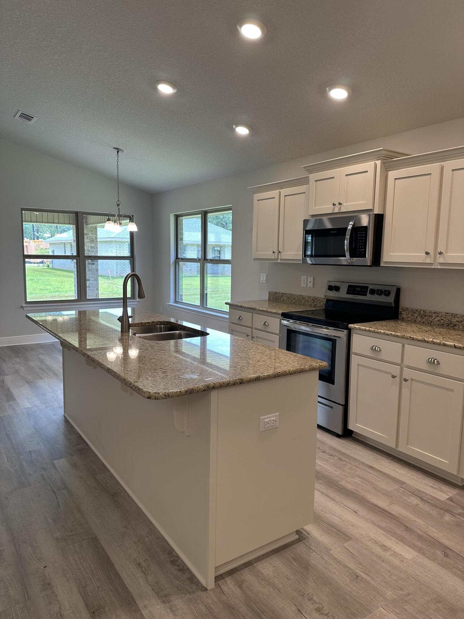 5287 Hidden Pines Circle Milton, FL 32583 - Photo 6 of 15 a kitchen with kitchen island granite countertop a sink a counter top space stainless steel appliances and a window
