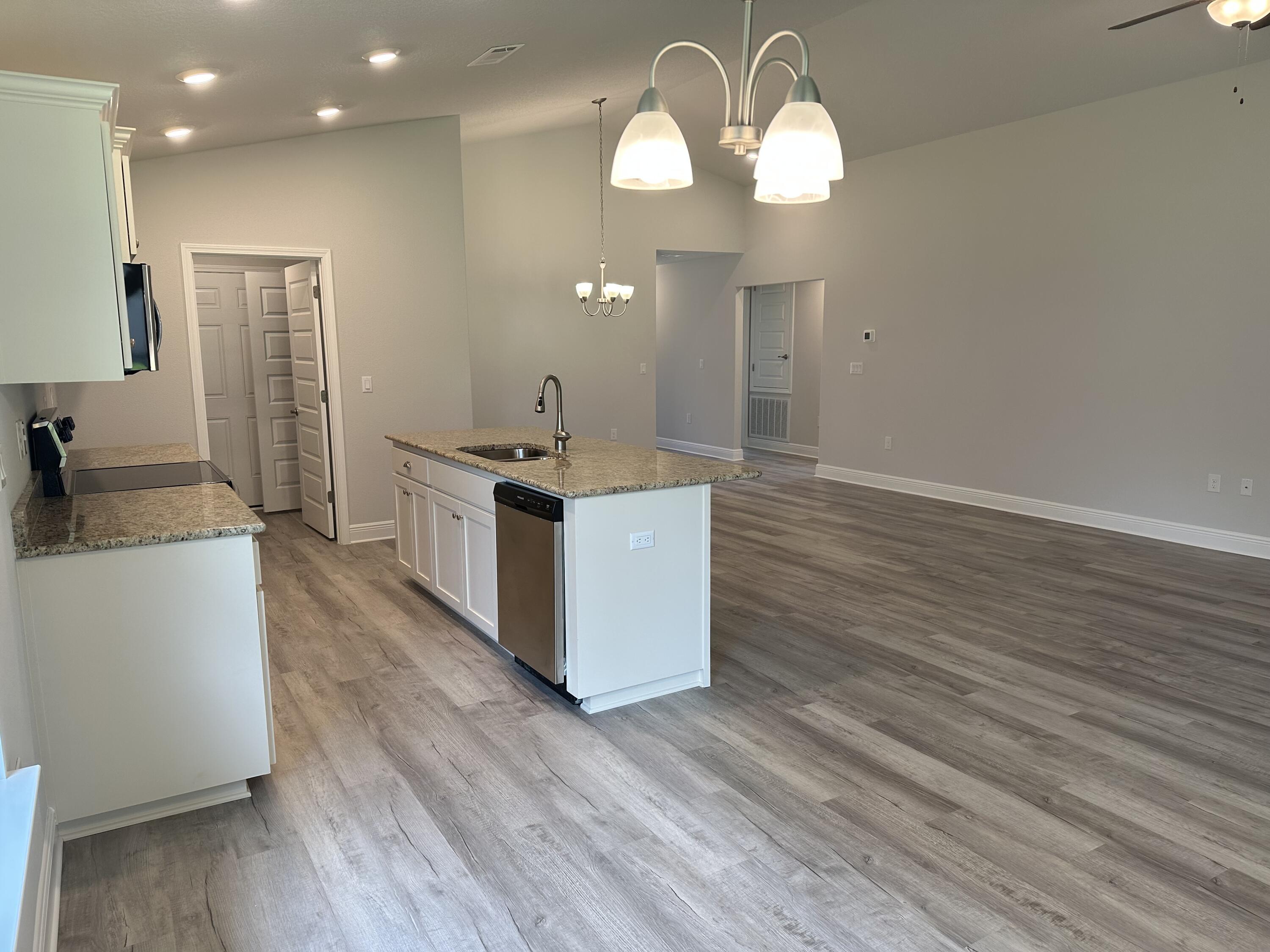5287 Hidden Pines Circle Milton, FL 32583 - Photo 7 of 15 a kitchen with stainless steel appliances granite countertop wooden floors and sink