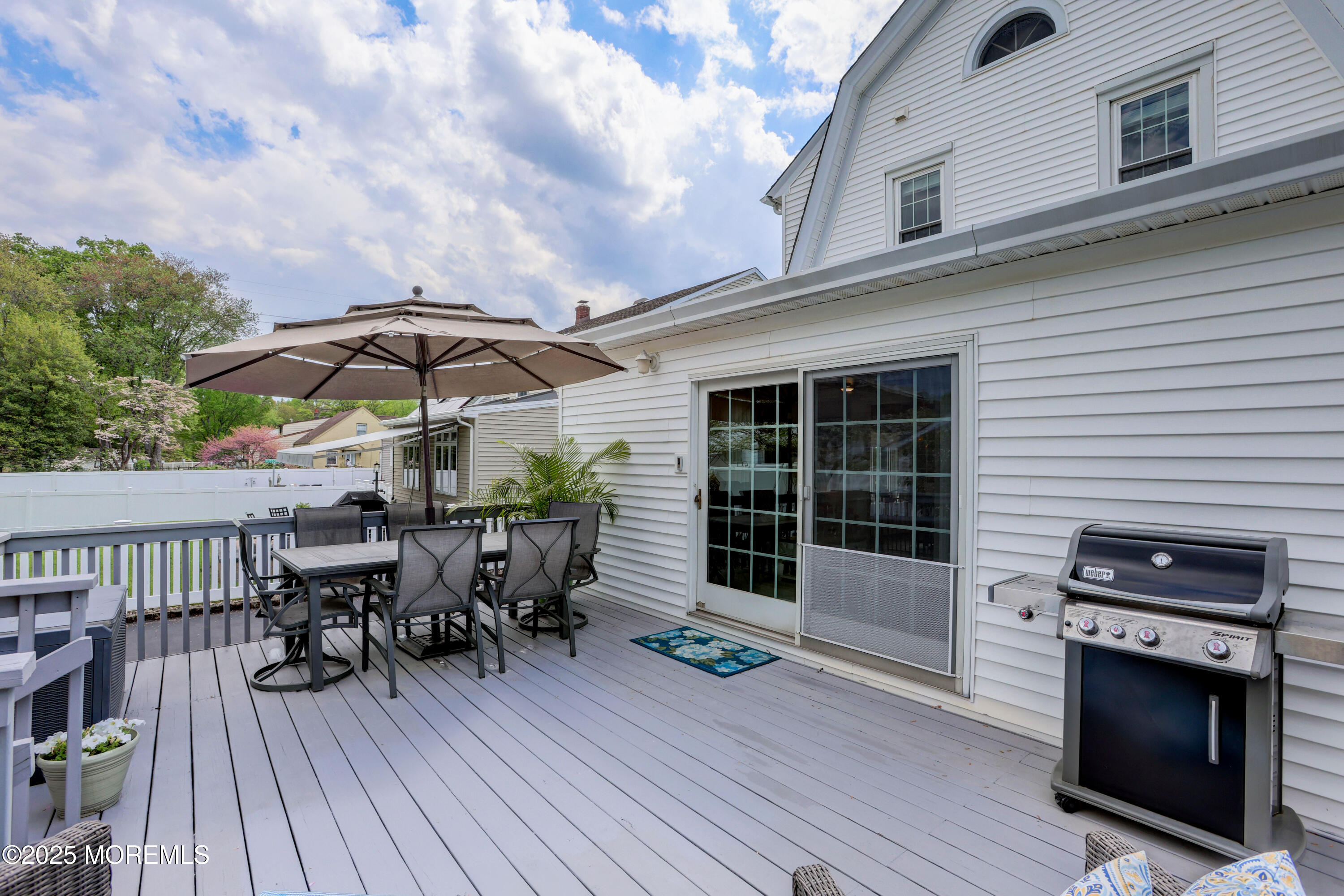 166 Grayson Avenue Hamilton, NJ 08619 - Photo 22 of 31 a view of a roof deck with table and chairs under an umbrella with wooden floor