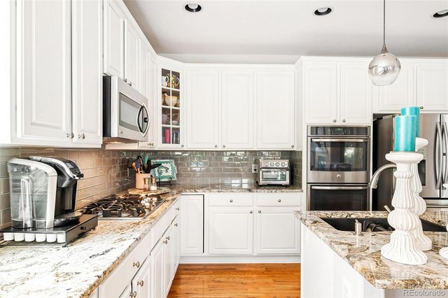 a kitchen with stainless steel appliances kitchen island granite countertop a sink and cabinets