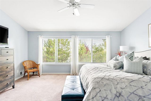 a bedroom with a bed a chair and a chandelier
