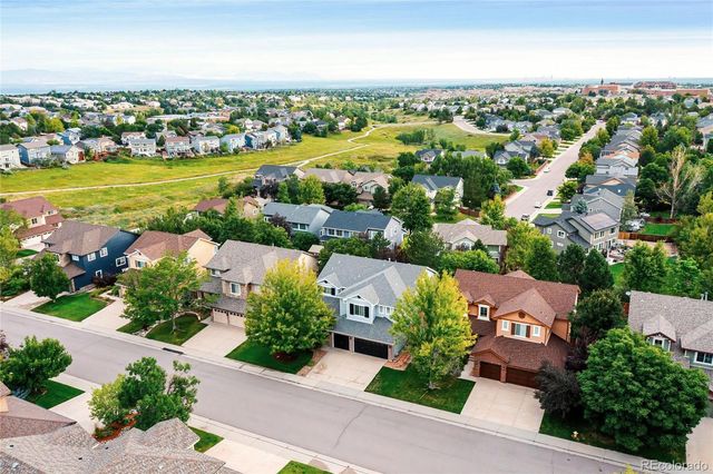 an aerial view of a city with lots of residential buildings ocean and mountain view in back
