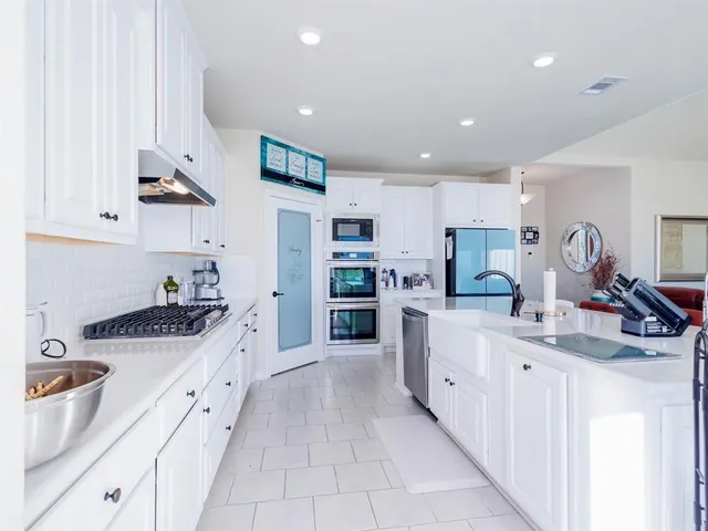 a kitchen with stainless steel appliances kitchen island granite countertop a sink and cabinets