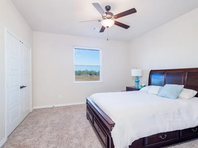 a bedroom with a large bed and a chandelier