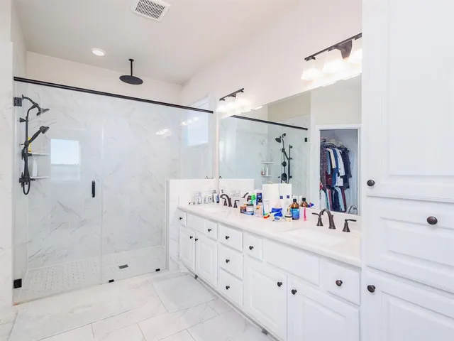 a bathroom with a double vanity sink mirror double and shower