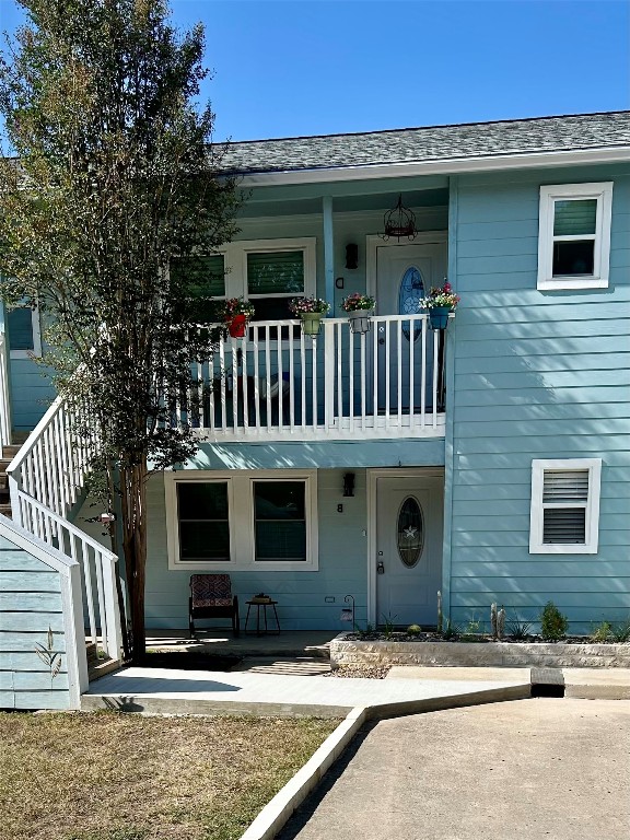 358 Shady Bluff Drive, Unit B Wimberley, TX 78676 - Photo 27 of 30 View of front facade with a balcony, a patio area, and uncovered parking