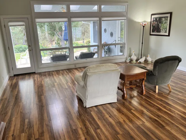 a dining room with wooden floor and a floor to ceiling window