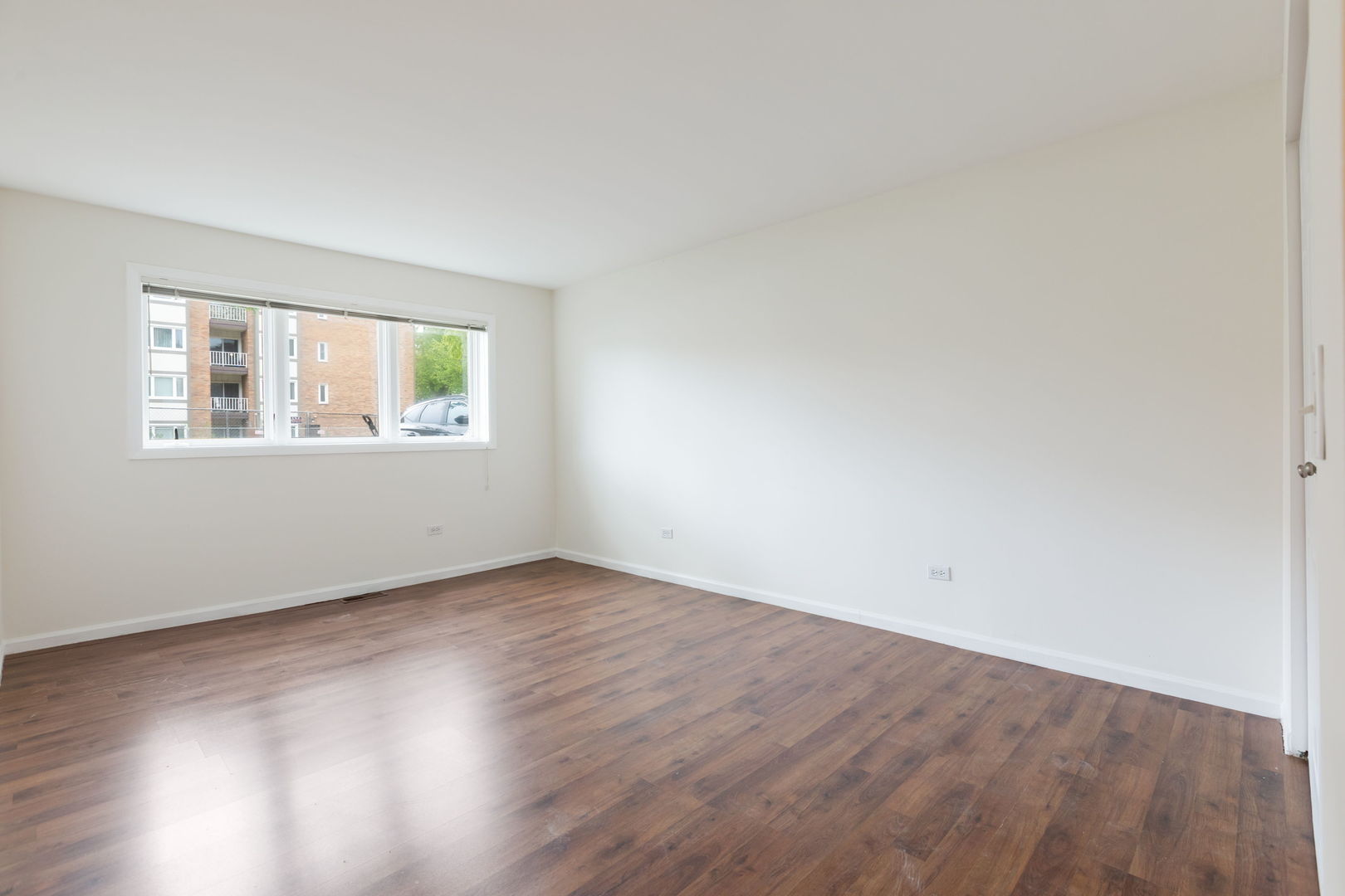 435 Ridge Road, Unit 108 Wilmette, IL 60091 - Photo 9 of 18 an empty room with wooden floor and windows