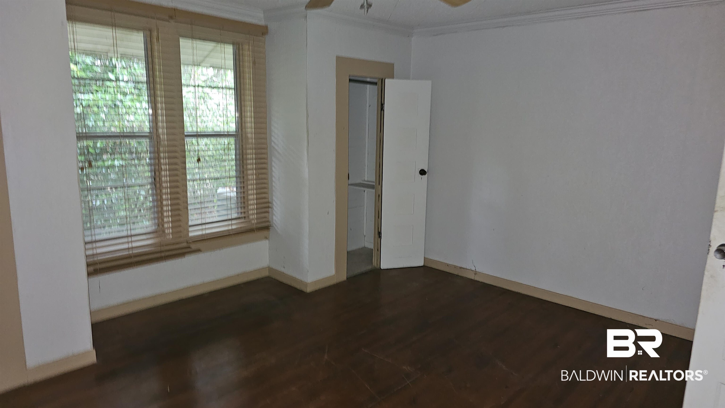 307 Scott Street Brewton, AL 36426 - Photo 13 of 19 Spare room with crown molding, dark wood-type flooring, and ceiling fan