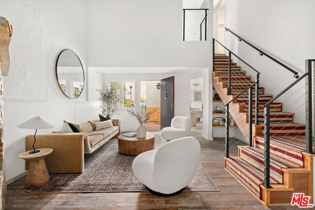 a living room with furniture a rug and white walls