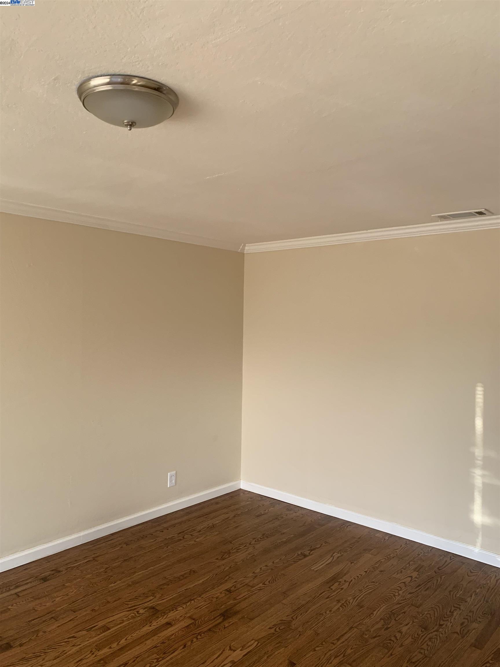 26730 Tyrrell Avenue Hayward, CA 94544 - Photo 14 of 26 a view of an empty room with wooden floor and a window