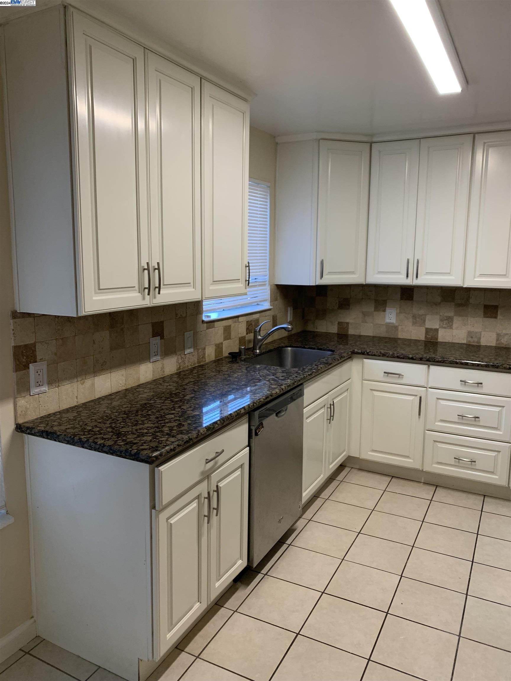 26730 Tyrrell Avenue Hayward, CA 94544 - Photo 7 of 26 a white kitchen with granite countertop white cabinets