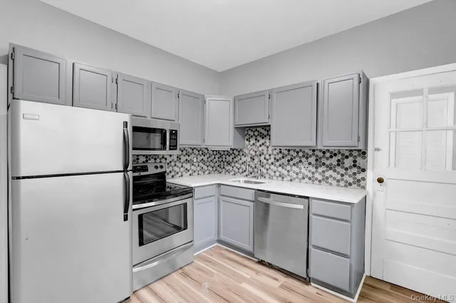 a kitchen with granite countertop white cabinets and white stainless steel appliances