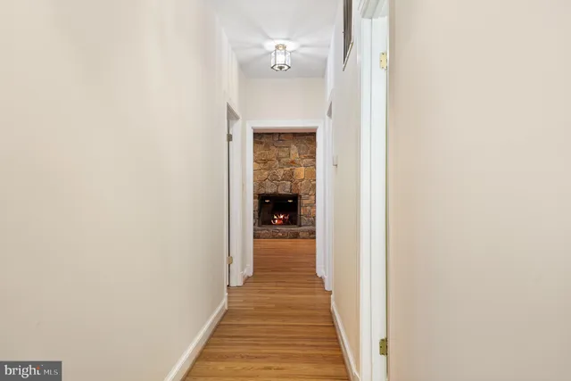 a view of empty room with wooden floor and fireplace