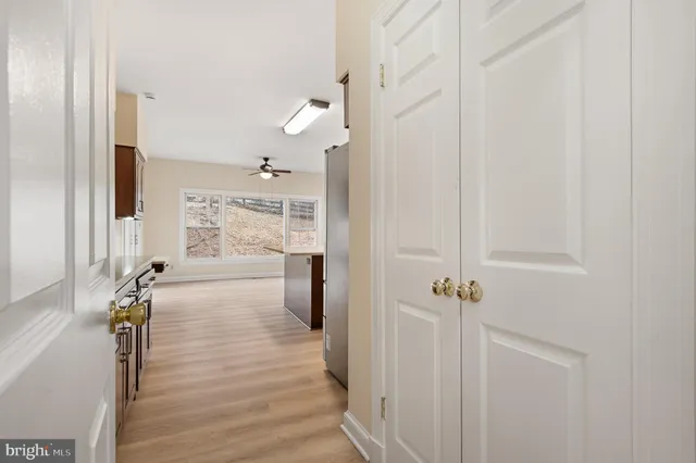 an empty room with wooden floor fireplace and windows