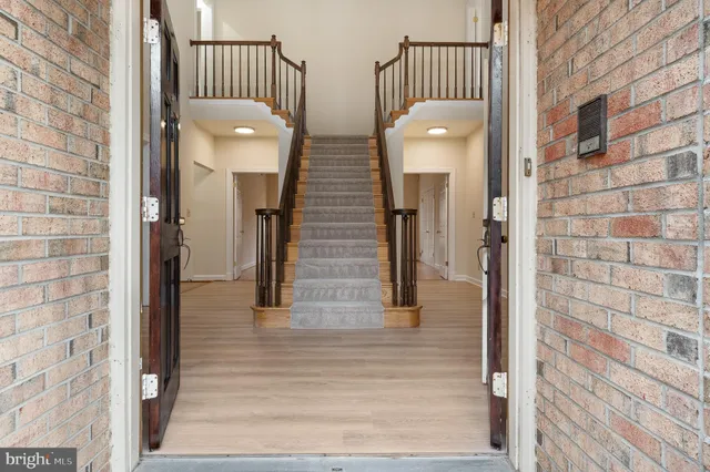 a view of an empty room with wooden floor and a fireplace