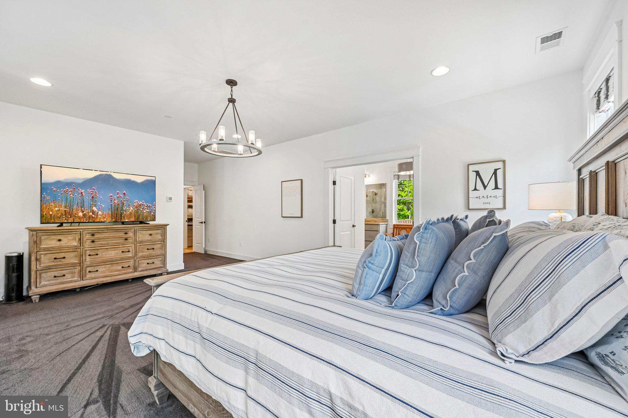 14516 Old Frederick Road Cooksville, MD 21723 - Photo 59 of 100 a spacious bedroom with a bed a dresser and flat screen tv
