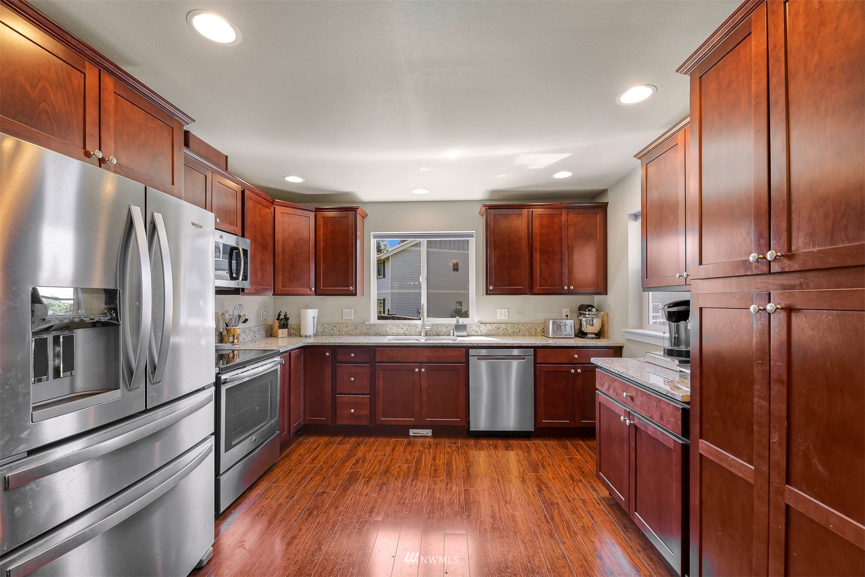 4601 Hall Road Blaine, WA 98230 - Photo 17 of 39 a large kitchen with wooden floors stainless steel appliances and cabinets