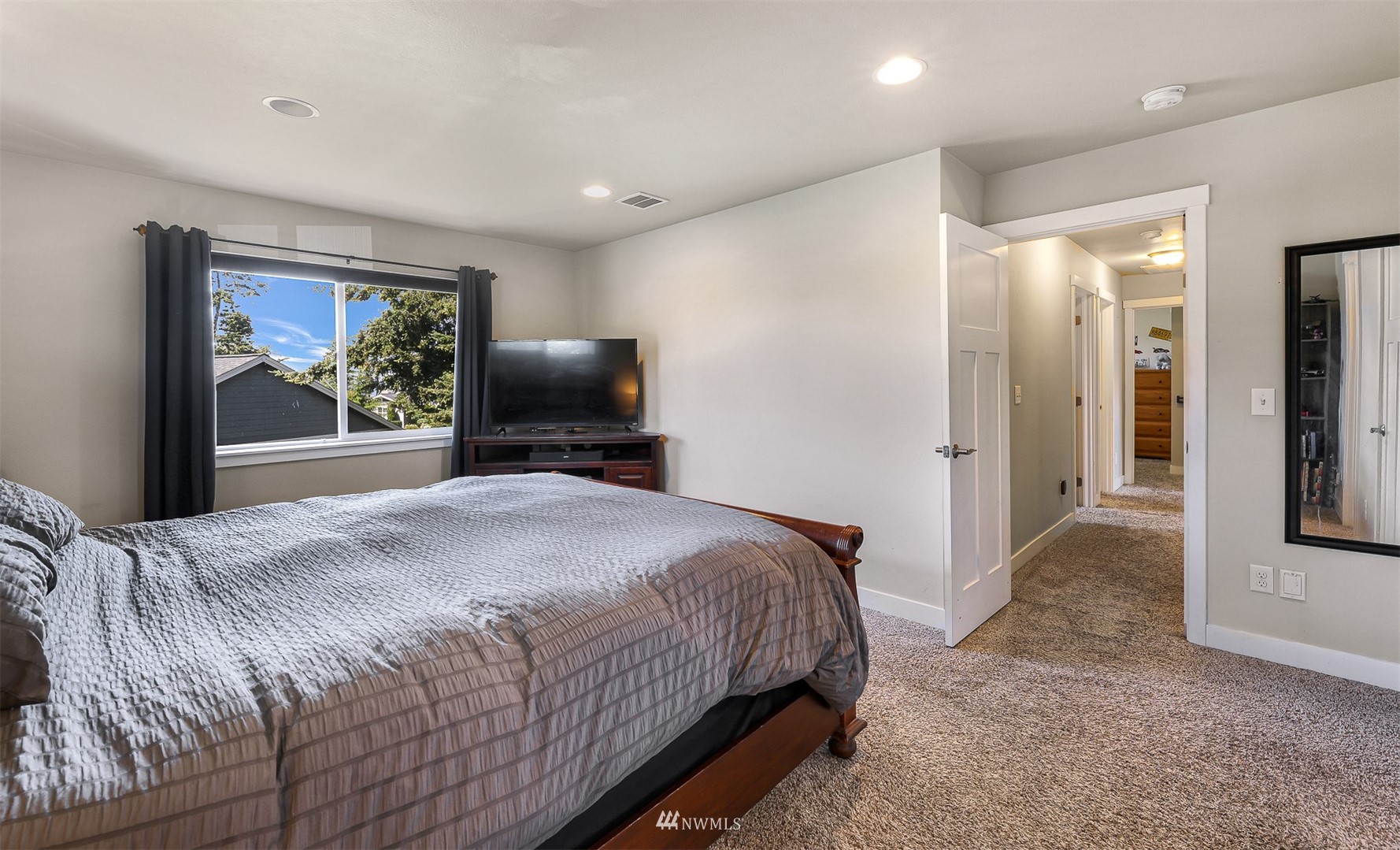 4601 Hall Road Blaine, WA 98230 - Photo 26 of 39 a bedroom with a large bed and a chandelier