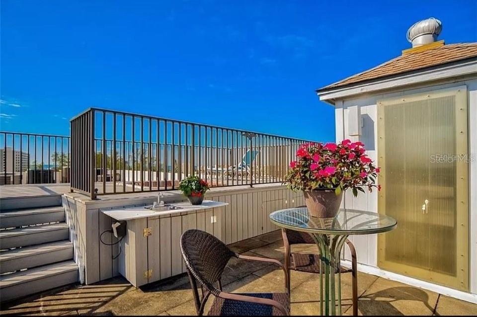 5911 Midnight Pass Road, Unit 601 Sarasota, FL 34242 - Photo 24 of 48 a patio with table and chairs