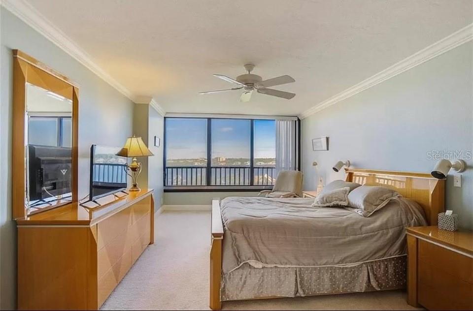 5911 Midnight Pass Road, Unit 601 Sarasota, FL 34242 - Photo 26 of 48 a bedroom with a bed and a chandelier