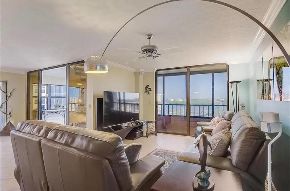 5911 Midnight Pass Road, Unit 601 Sarasota, FL 34242 - Photo 34 of 48 a living room with furniture a ceiling fan and a flat screen tv