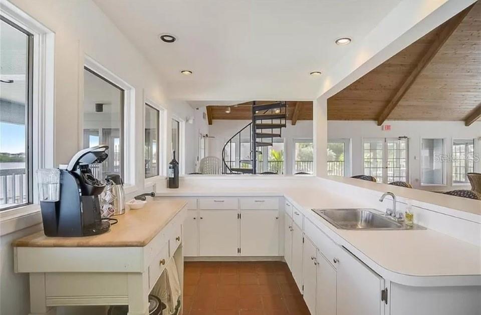 5911 Midnight Pass Road, Unit 601 Sarasota, FL 34242 - Photo 45 of 48 a kitchen with a sink stove and cabinets
