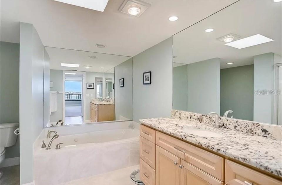 5911 Midnight Pass Road, Unit 601 Sarasota, FL 34242 - Photo 5 of 48 a spacious bathroom with a tub sink and a mirror